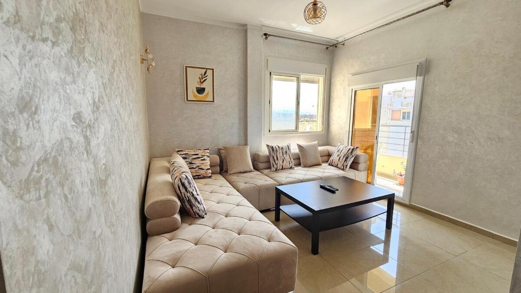 a living room with a couch and a table at Le Nid Côtier in Briech