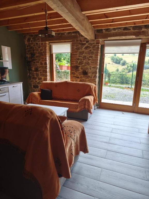 a living room with two beds and a window at El Llugar de las Drusas in Fontanina