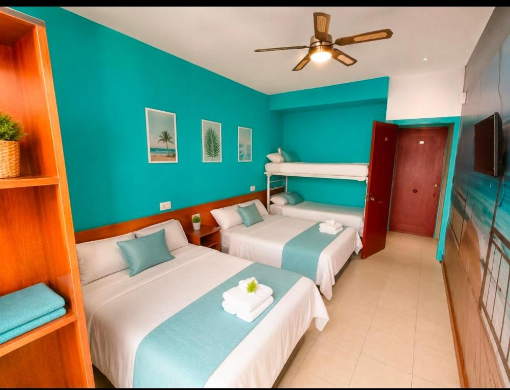 two beds in a room with blue walls at Guesthouse Tossa de Mar in Tossa de Mar