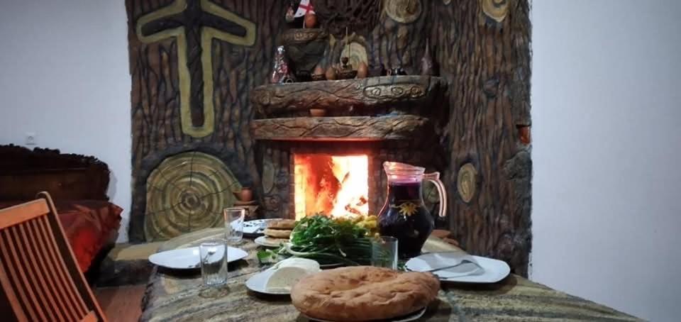 a table with a fireplace in a dining room at Weekend House in Borjomi