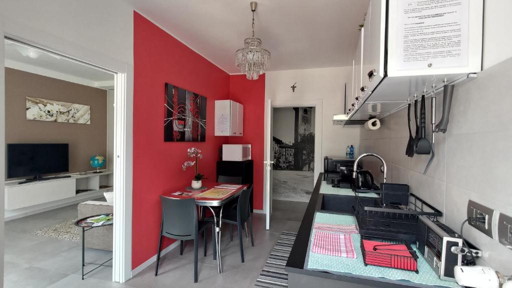 a kitchen and dining room with a red wall at Design apartment n. 41 in Trento