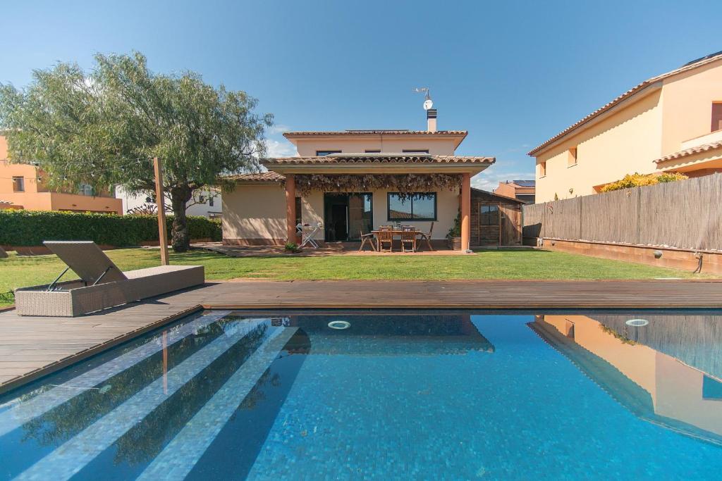 a swimming pool in front of a house at WELCS CASA 423 PDA con piscina in Vall-Llobrega