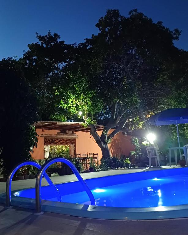 a swimming pool at night with a blue pool at Pousada Água de Côco in Prado