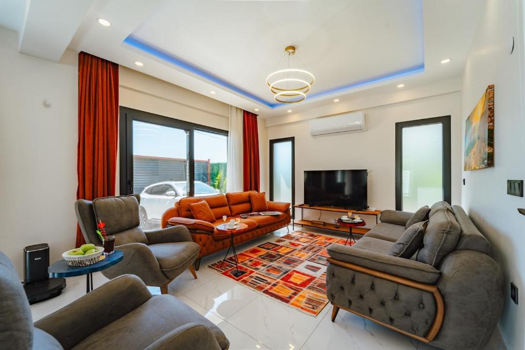 a living room with couches and a flat screen tv at Villa Bella in Doger Koyu