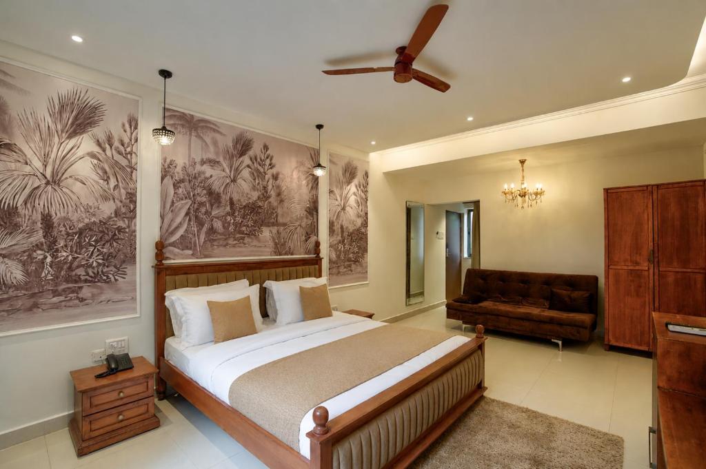 a bedroom with a large bed and a couch at Ocean n' Sand - By Q23 Resorts & Suites in Candolim