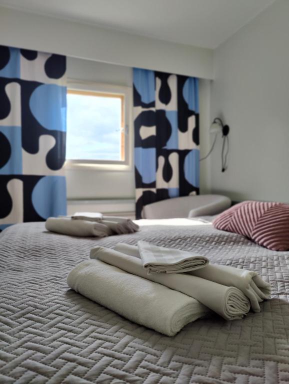 two beds with towels on them in a bedroom at Wanha Mannila in Savonlinna