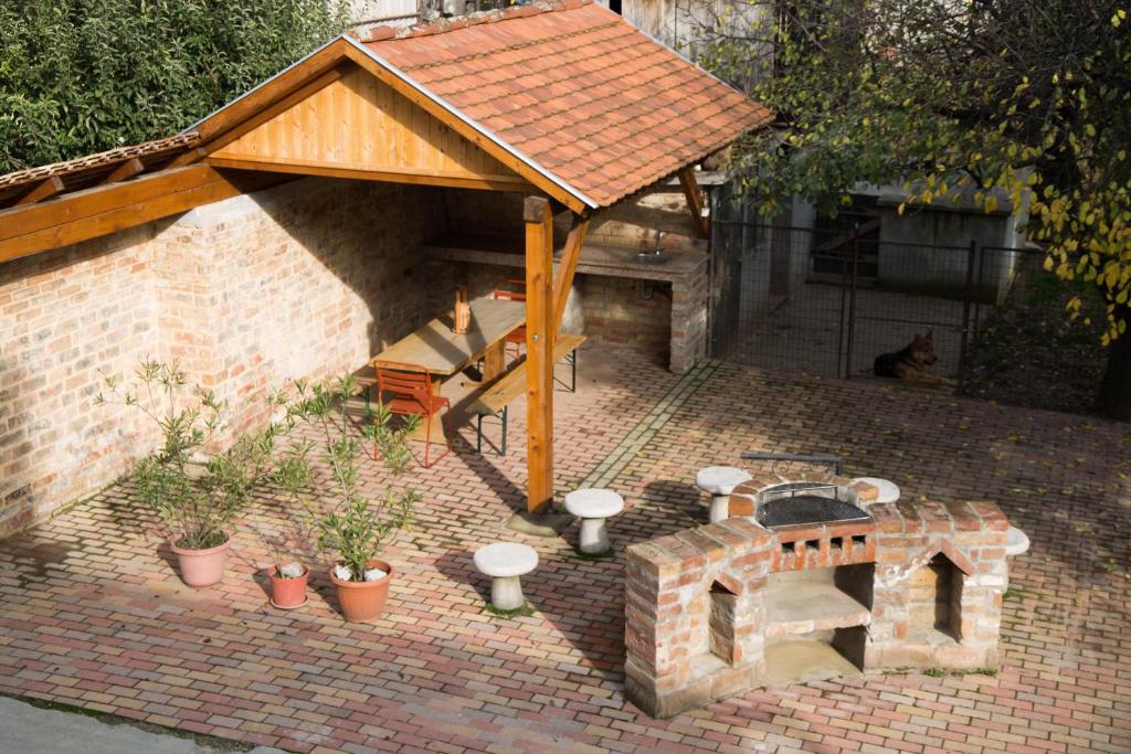 un patio de ladrillo con chimenea y techo de madera en Tompos Vendégház és pince, en Villány