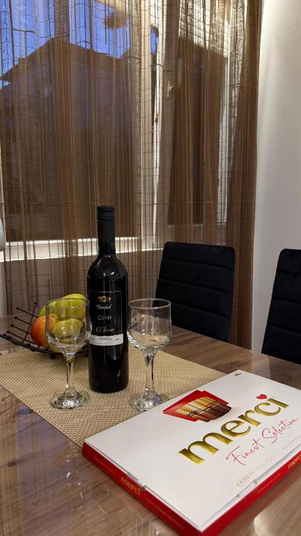 a bottle of wine and two glasses on a table at Urban Apartment Karpoš in Skopje