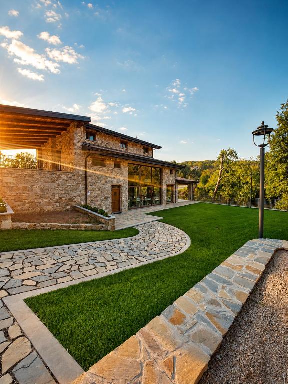 a building with a stone walkway in front of a yard at Domus Lauri in Laurino