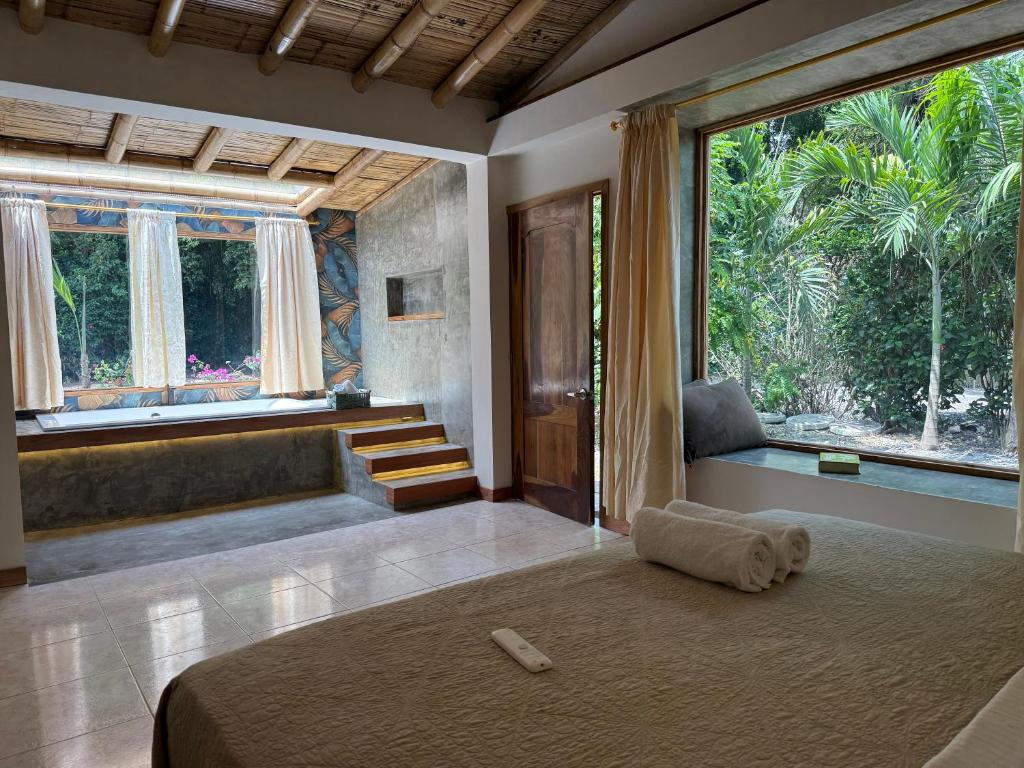 a bedroom with a bed and a large window at Casa Peregrina in Ayampe