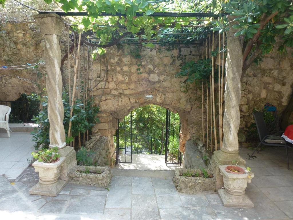 un arco en una pared de piedra con plantas en ollas en Villa Fede, en Mlini