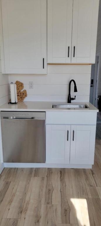 a kitchen with white cabinets and a sink at SANDY BEACH Paradise On The Beach in Lincoln Junction