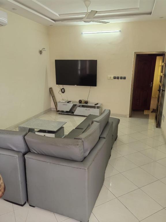 a living room with a couch and a flat screen tv at Appartement 2 chambres salon in Cotonou