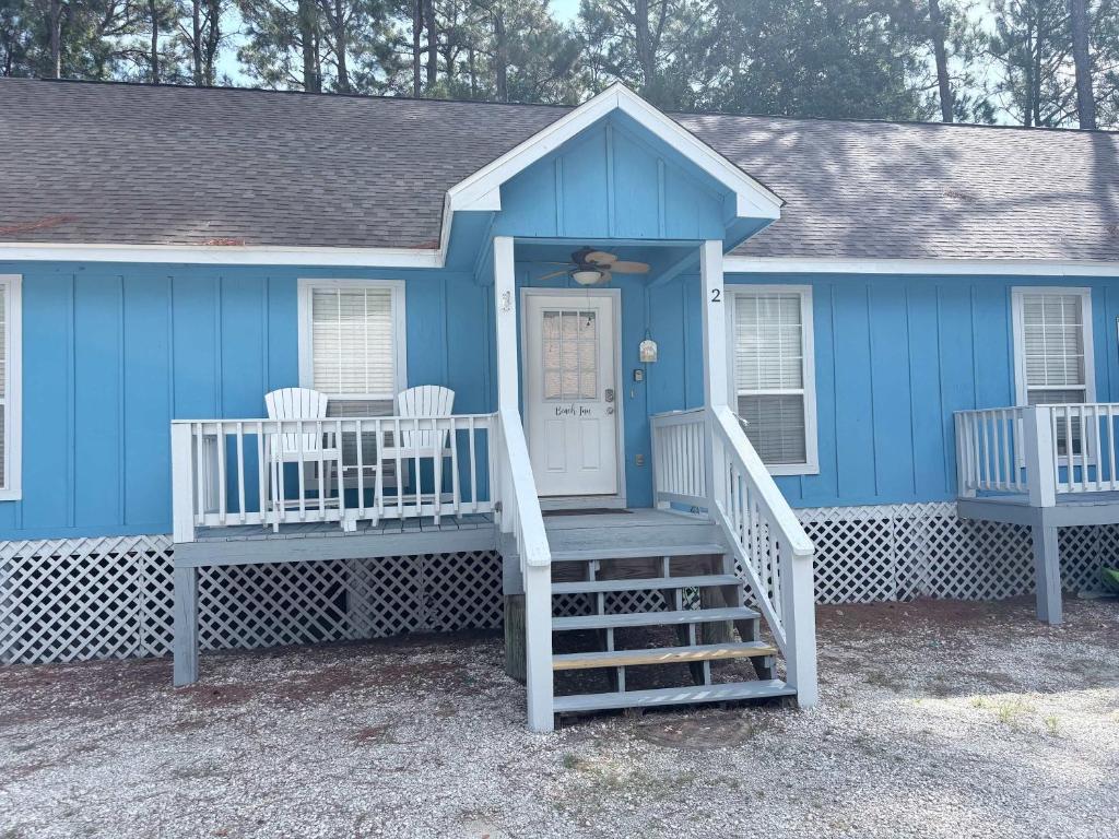 a blue house with two chairs in front of it at Perfectly located condo with beach access - deck internet W&D & AC in Dauphin Island