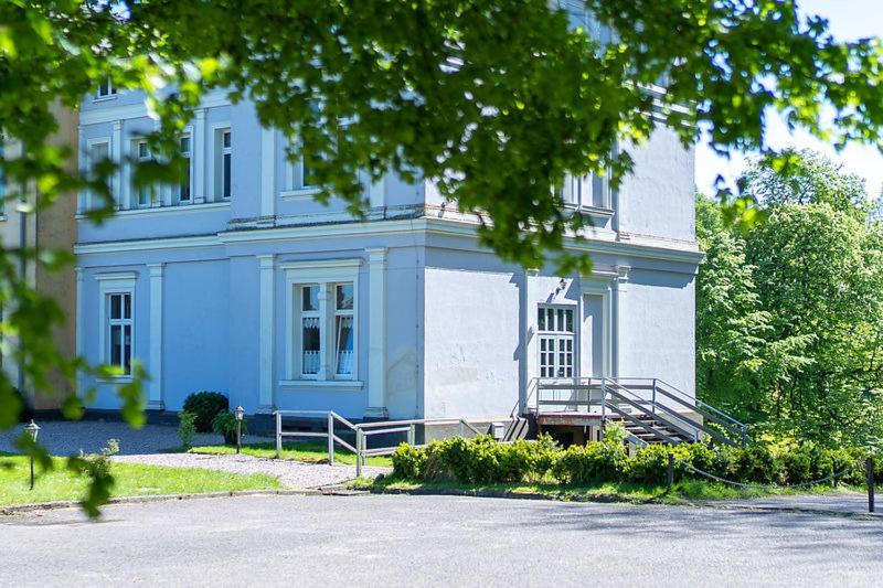ein großes blau-weißes Gebäude mit einer Treppe in der Unterkunft Wohnstudio auf Schloss Semlow in Semlow