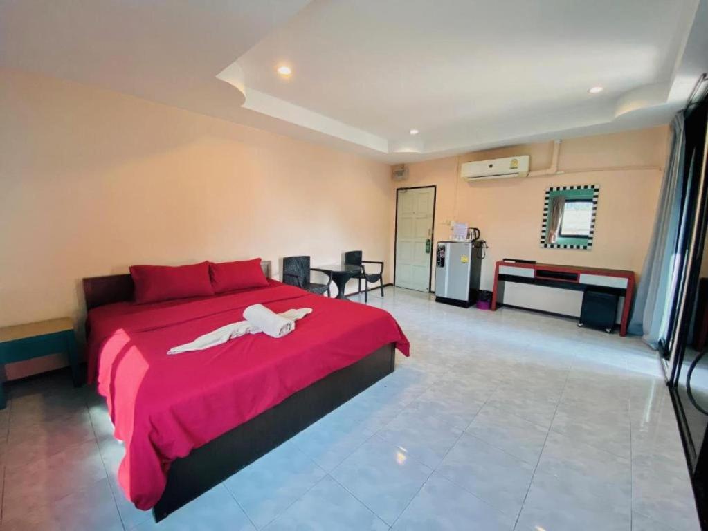 a bedroom with a red bed with a white animal on it at Apartment X5 in Pattaya South