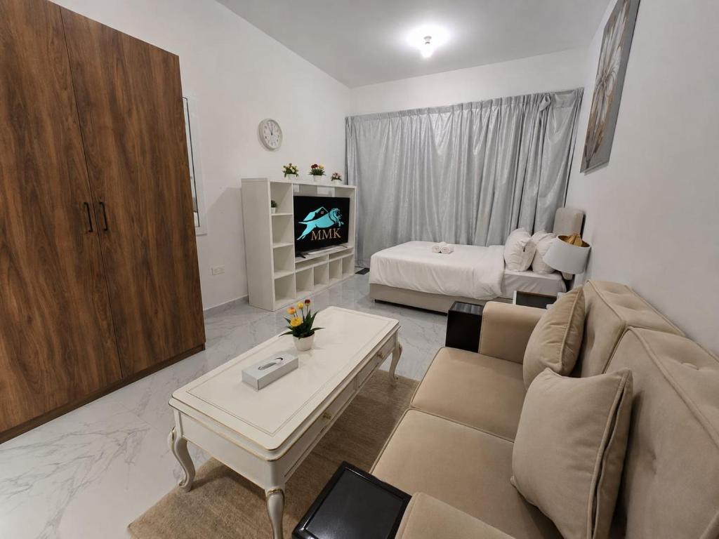 a living room with a couch and a tv at شقة مصدر in Abu Dhabi