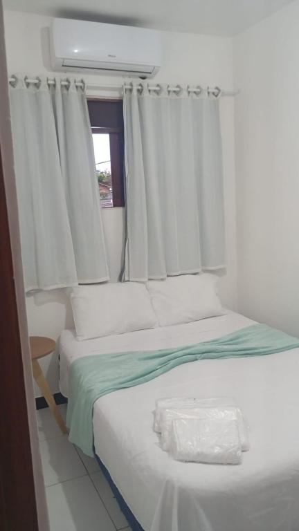 a bedroom with two beds and a window at Pousada dos Marujos in Pipa