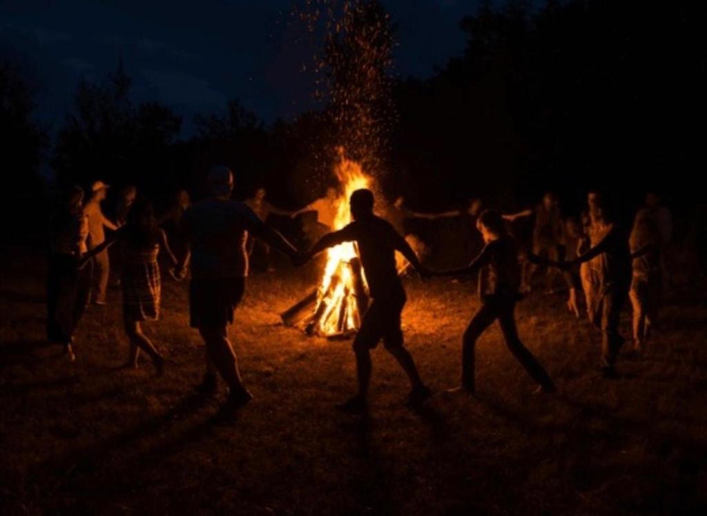 a group of people dancing around a bonfire at night at Spatika Villa in Madikeri