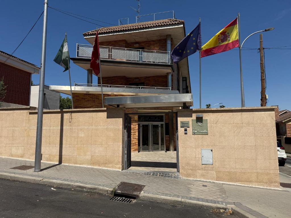 a building with flags in front of it on a street at Hostal Los Coronales in Madrid