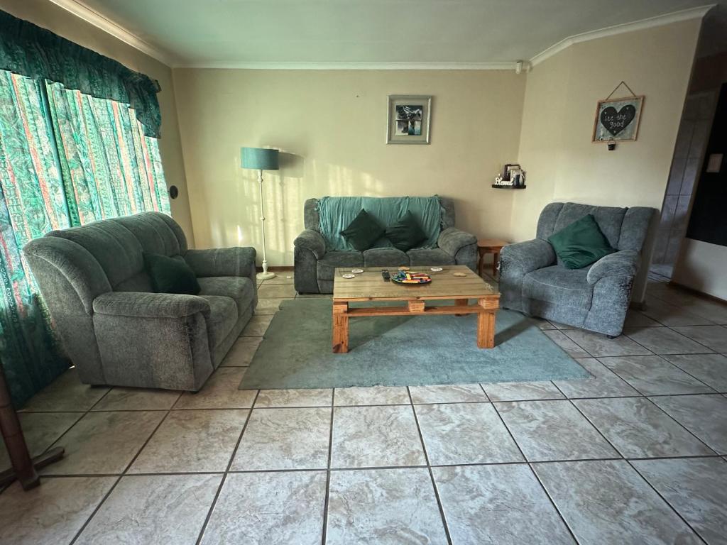 a living room with two couches and a coffee table at Spacious & serene townhouse getaway in Bloemfontein