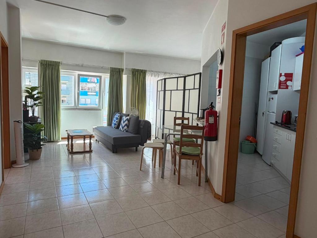 a living room with a couch and a table and chairs at Atlantic Romantic Caparica Flat in Costa da Caparica