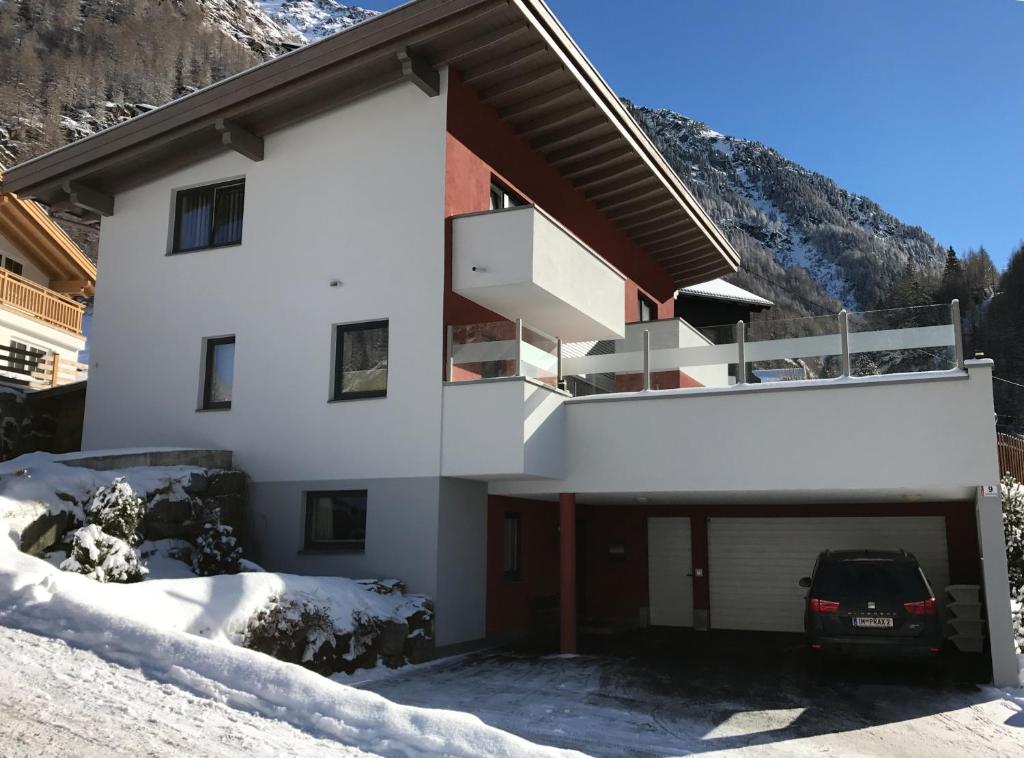 a white building with a balcony in the snow at Haus Praxmarer in Sölden