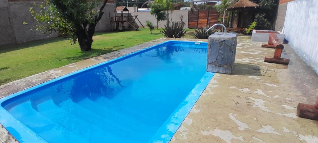 a swimming pool with blue water in a yard at The Thrush in Cañuelas