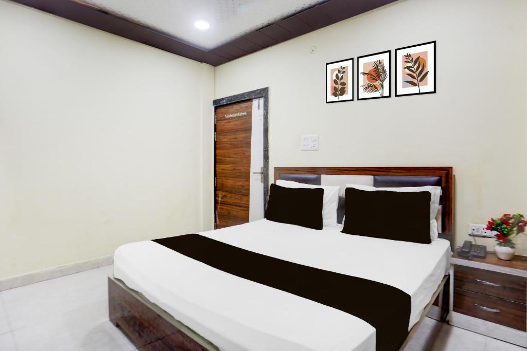 a bedroom with a large bed with white walls at HOTEL O RAJDHANI in Kānpur