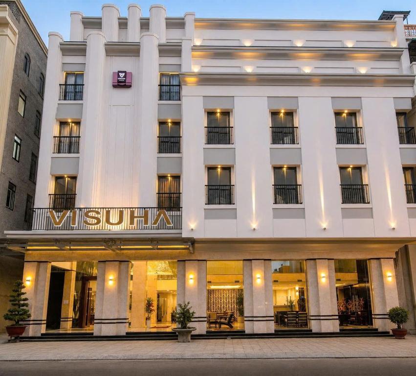 a large white building with a sign on it at VISUHA HOTEL in Hà Tiên