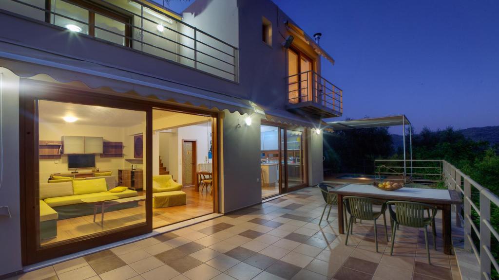 a house with a patio with a table and a couch at Villa Orgoni in Platanias