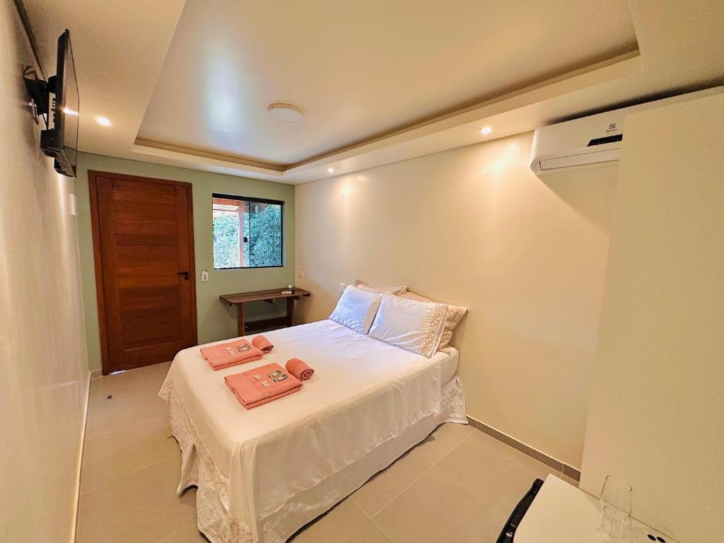 a bedroom with a bed with two towels on it at Pousada Cair do Sol in Ilha do Mel