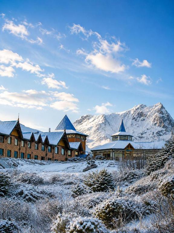 a group of buildings with snow covered mountains in the background at Los Ñires Ushuaia in Ushuaia