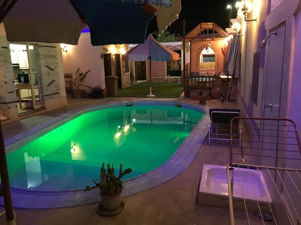 a large swimming pool at night with an umbrella at Guest House in Luxor