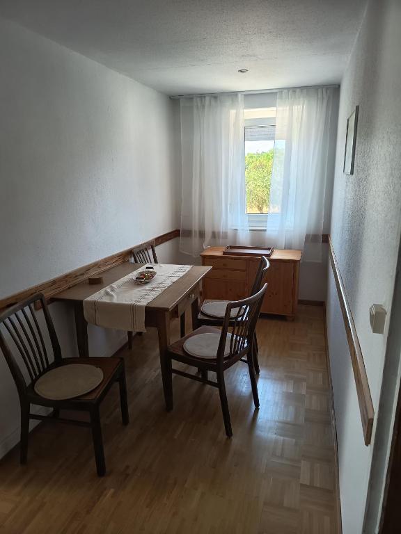 a dining room with a table and chairs and a window at Haus der Sonne Apartment in Blaufelden