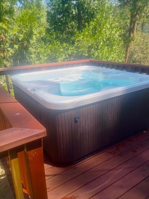 a large hot tub sitting on a deck at Orange Door Electric Fireplace bbq in Oakhurst