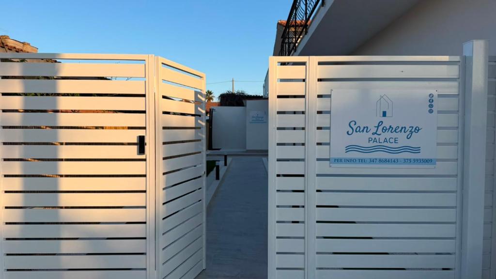 a pair of white fences next to a building at San Lorenzo Palace in Reitani