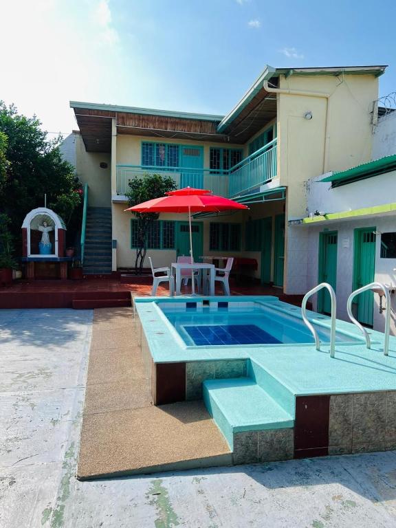 a swimming pool with a table and an umbrella at Casa quinta en Girardot in Girardot