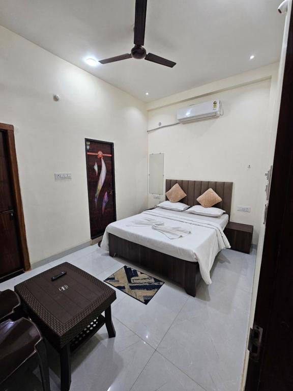 a bedroom with a bed and a table in it at Siyara Hotel in Khamaria