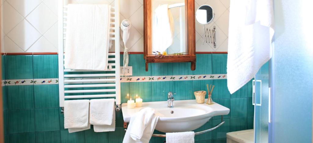 bagno con lavandino e specchio di Hotel Giardino Giamperduto a Bernalda