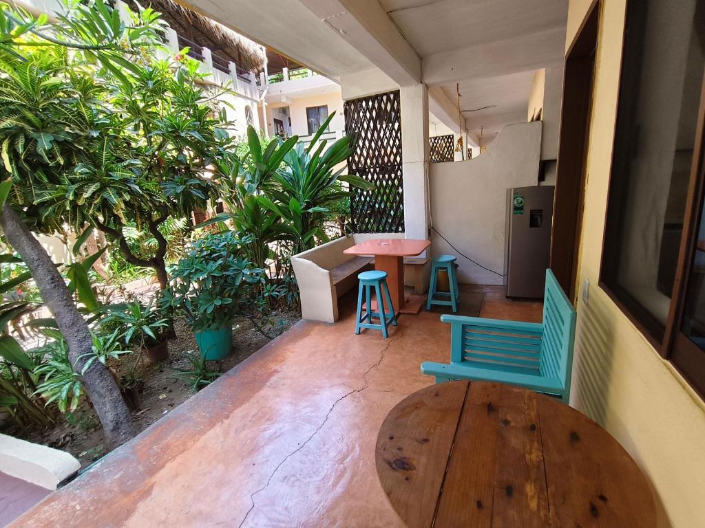 a porch with two chairs and a table and a table at Hotel Papaya Surf in Puerto Escondido
