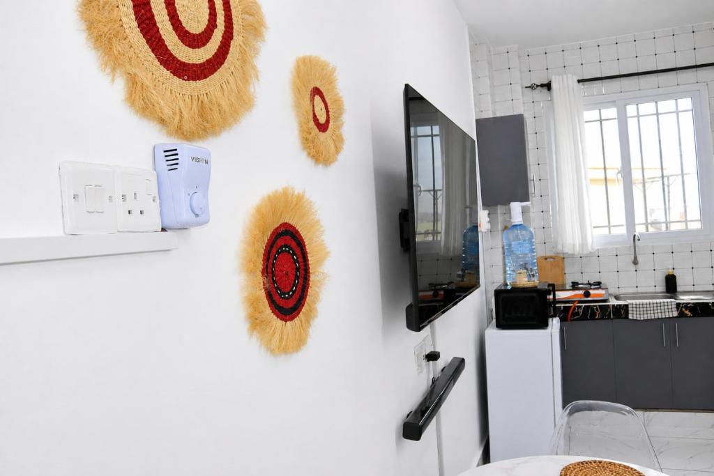a kitchen with white walls with decorations on the wall at Soft stay homes in Mombasa