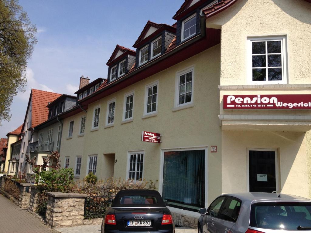 budynek z samochodami zaparkowanymi przed nim w obiekcie Pension Wegerich w mieście Erfurt