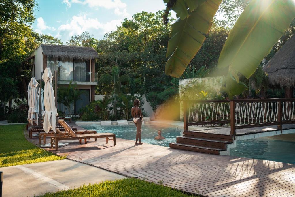a woman standing in the pool at a resort at Nalhá Hotel Boutique y Villas Bacalar in Bacalar