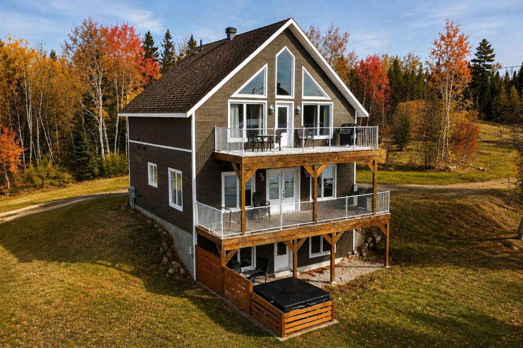 a house in the middle of a field at Le Huppe - Spa Ski & River View in Petite-Rivière-Saint-François