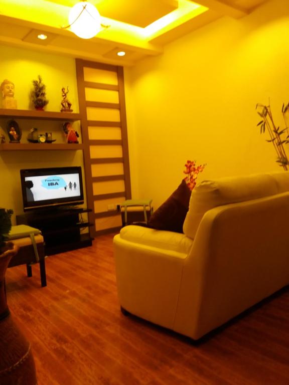 a living room with a white couch and a television at 722 Metropolis Tower Unit 212 in Bacolod