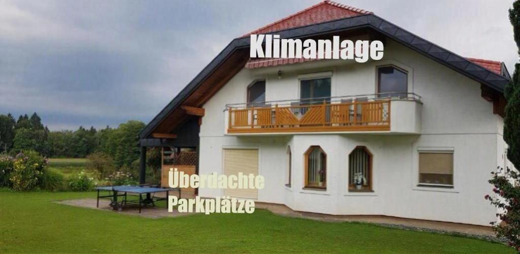 a house with a balcony and a picnic table at Ferienwohnung Silvia in Sankt Kanzian