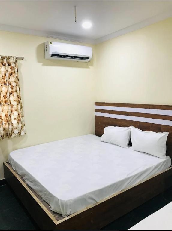 a bedroom with a bed and a air conditioner at HoTEL LAALASA in Vijayawāda