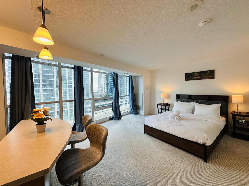 a hotel room with a bed and a table and chairs at Victoria Suites - Downtown in Toronto