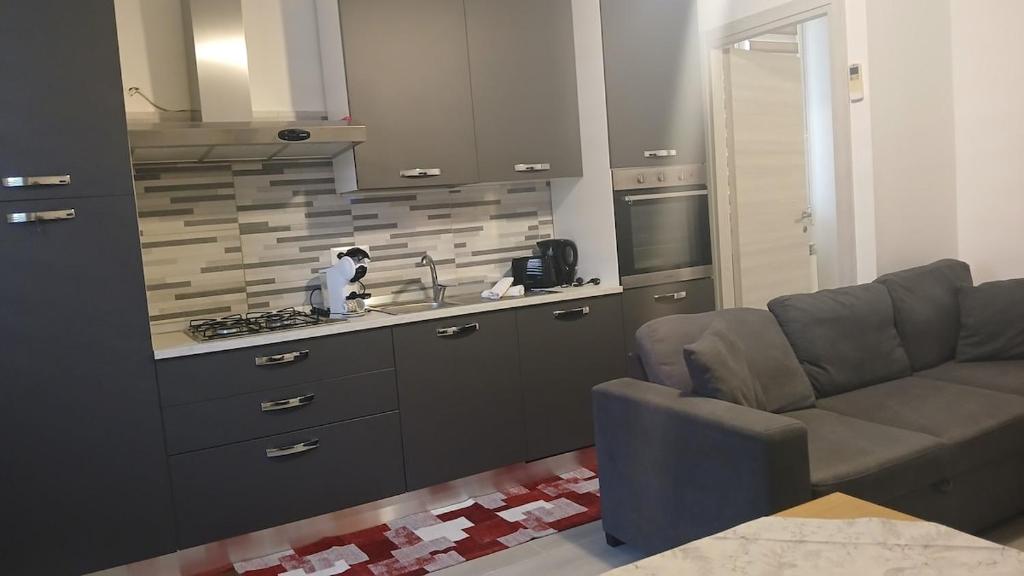 a living room with a couch and a kitchen at Appartamento perla in Rome